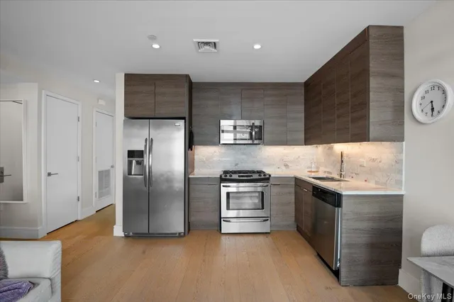 a kitchen with stainless steel appliances granite countertop a refrigerator sink and stove
