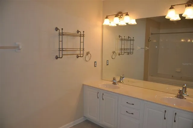 a bathroom with a double vanity sink and a mirror