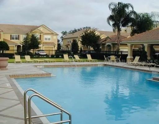 a view of a house with pool and chairs