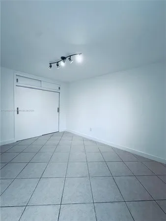 a view of an empty room and chandelier fan