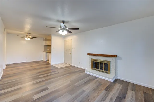 a view of an empty room with a fireplace and a fan