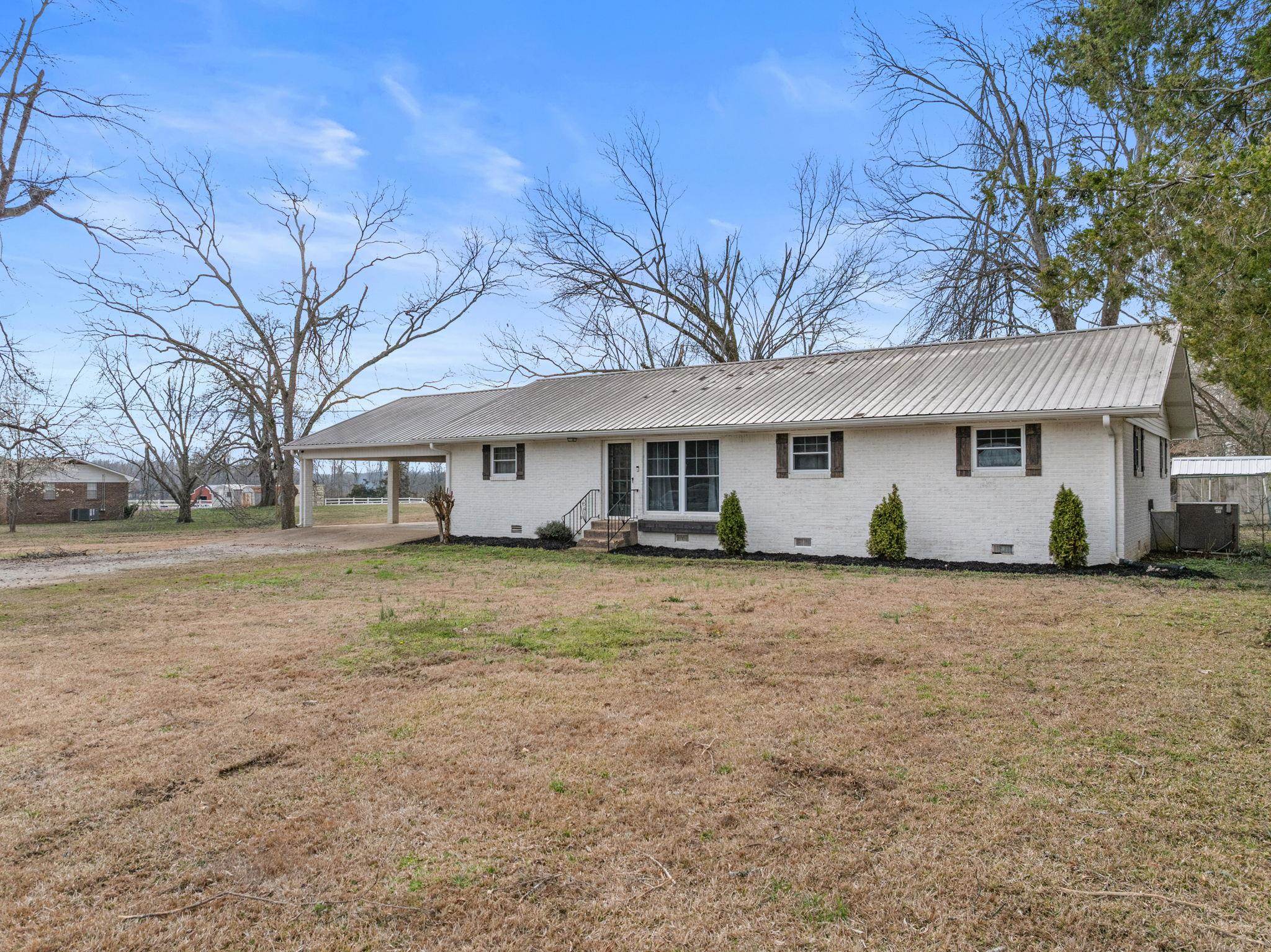 12 County Road 512 Corinth, MS 38834 - Photo 12 of 39 Ranch-style house with crawl space, a metal roof, a carport, brick siding, and a front lawn