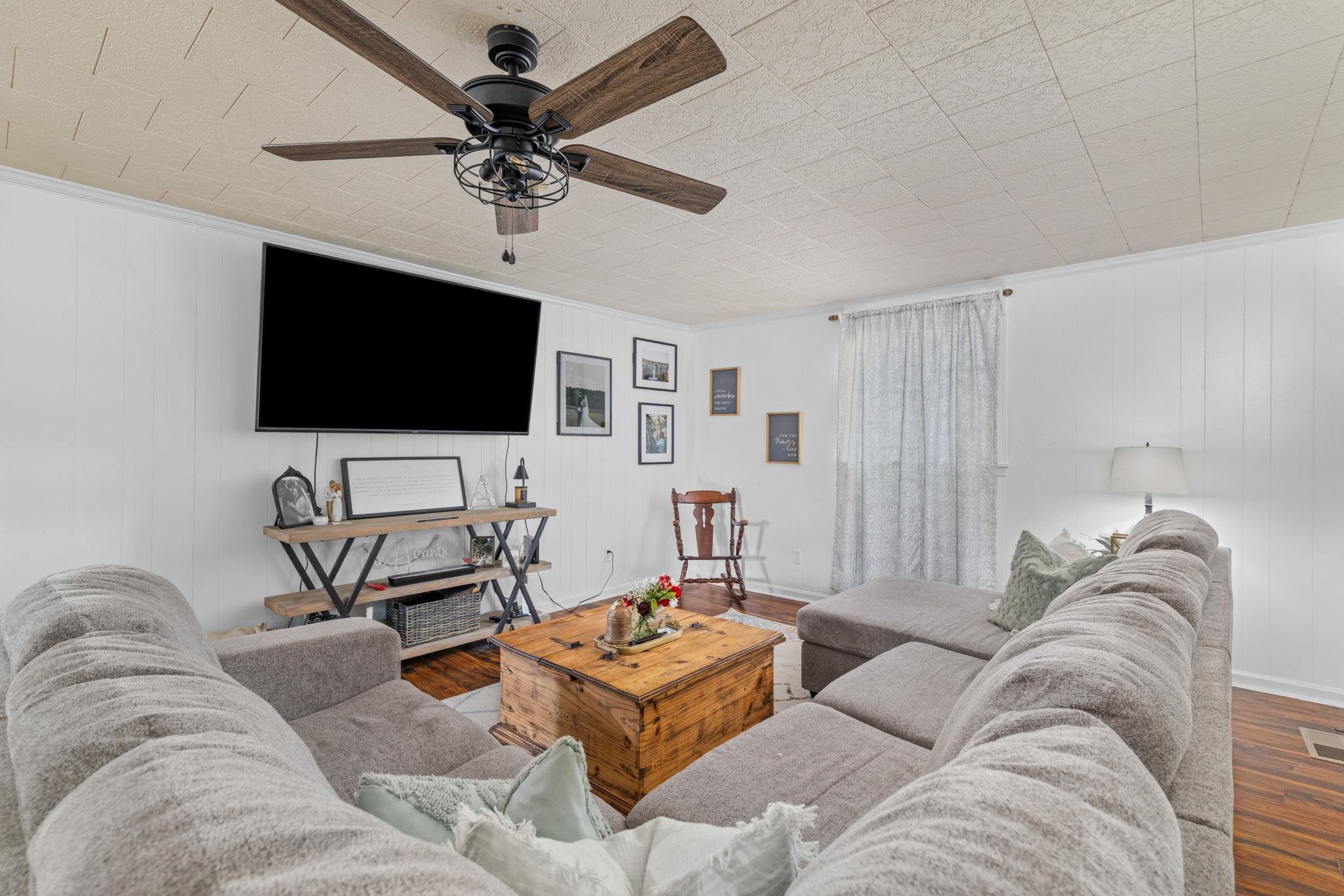 12 County Road 512 Corinth, MS 38834 - Photo 16 of 39 Living area with wood finished floors, a ceiling fan, and wood walls