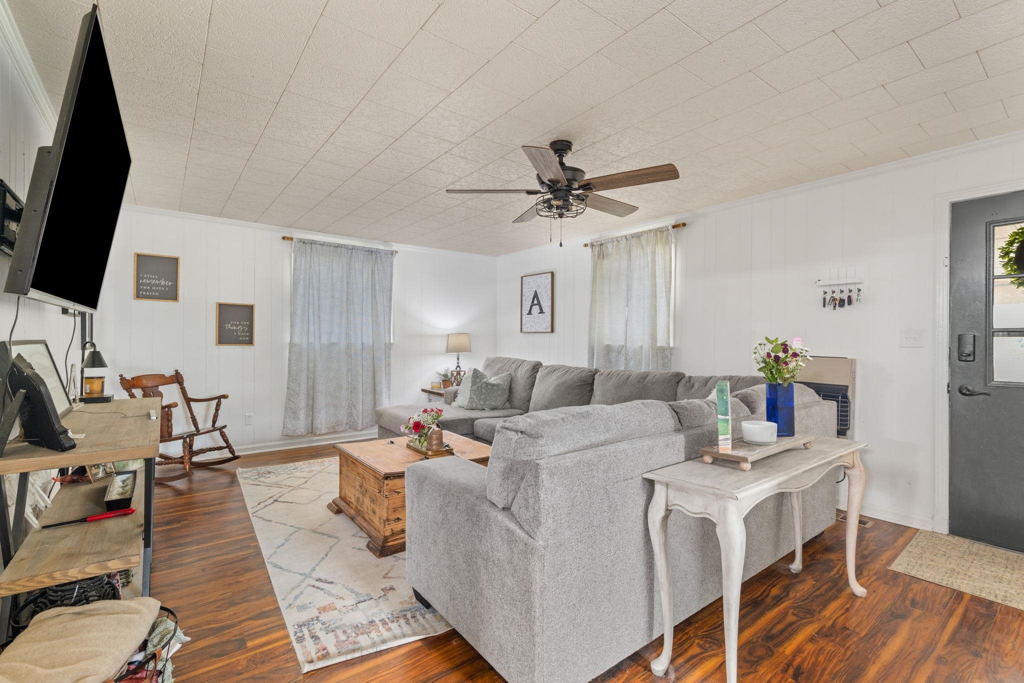 12 County Road 512 Corinth, MS 38834 - Photo 17 of 39 Living room featuring dark wood-style flooring, ornamental molding, and ceiling fan