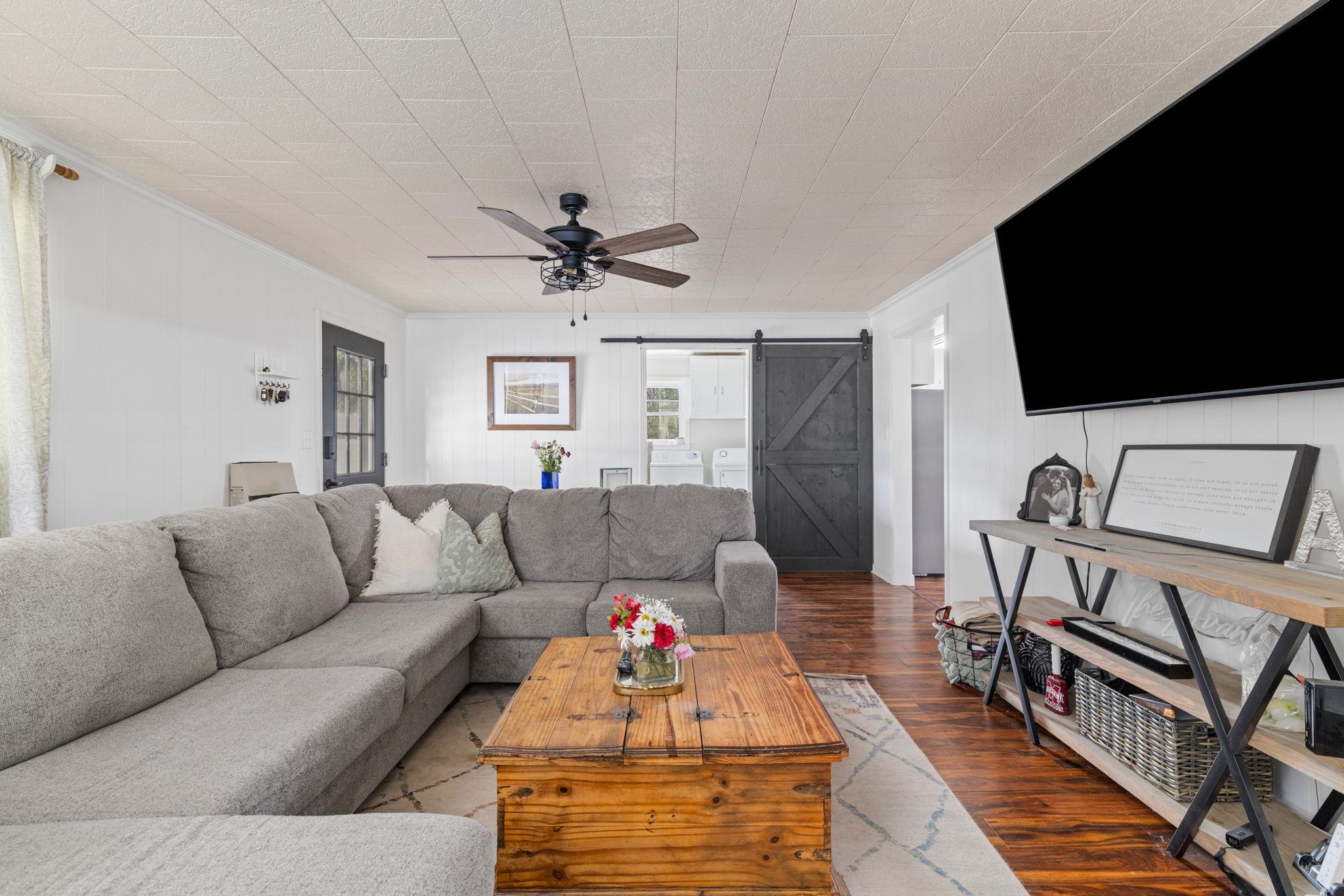 12 County Road 512 Corinth, MS 38834 - Photo 18 of 39 Living room featuring a barn door, wood finished floors, crown molding, ceiling fan, and plenty of natural light
