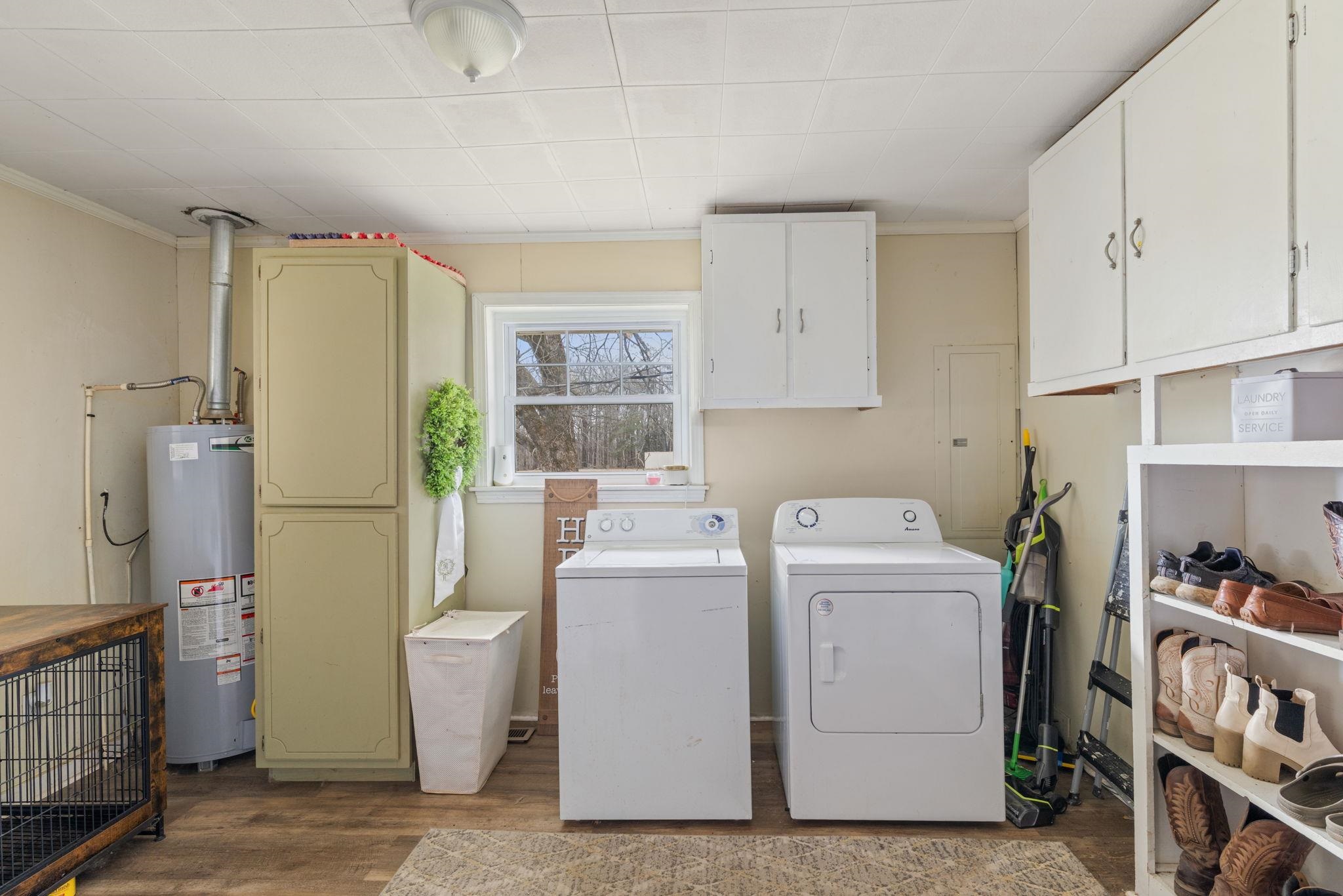 12 County Road 512 Corinth, MS 38834 - Photo 19 of 39 Laundry room featuring cabinet space, dark wood-style floors, gas water heater, washer and clothes dryer, and crown molding