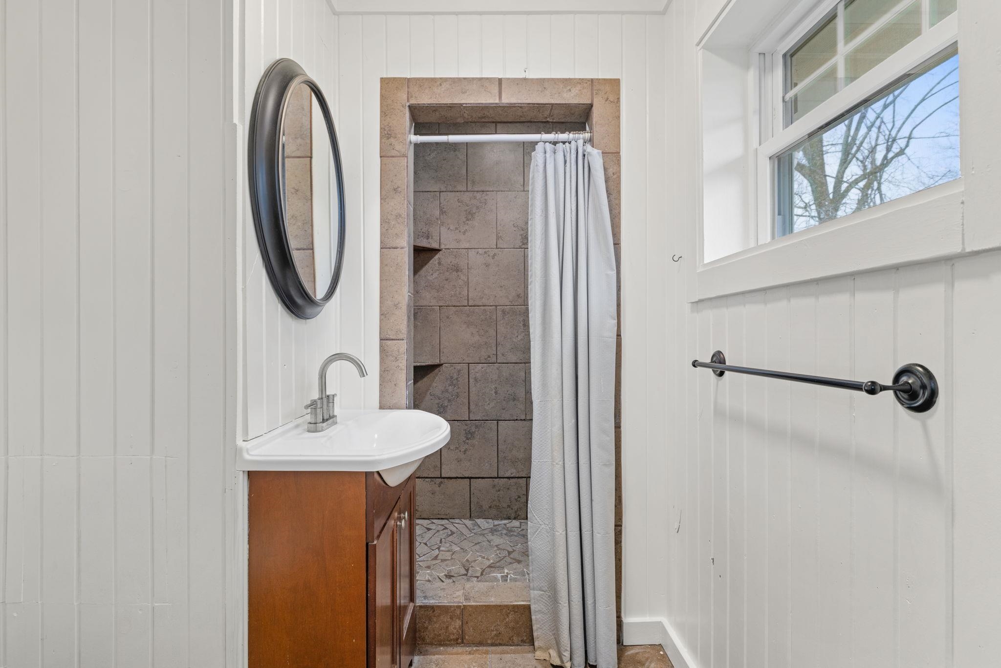12 County Road 512 Corinth, MS 38834 - Photo 33 of 39 Bathroom with wooden walls, vanity, and a stall shower