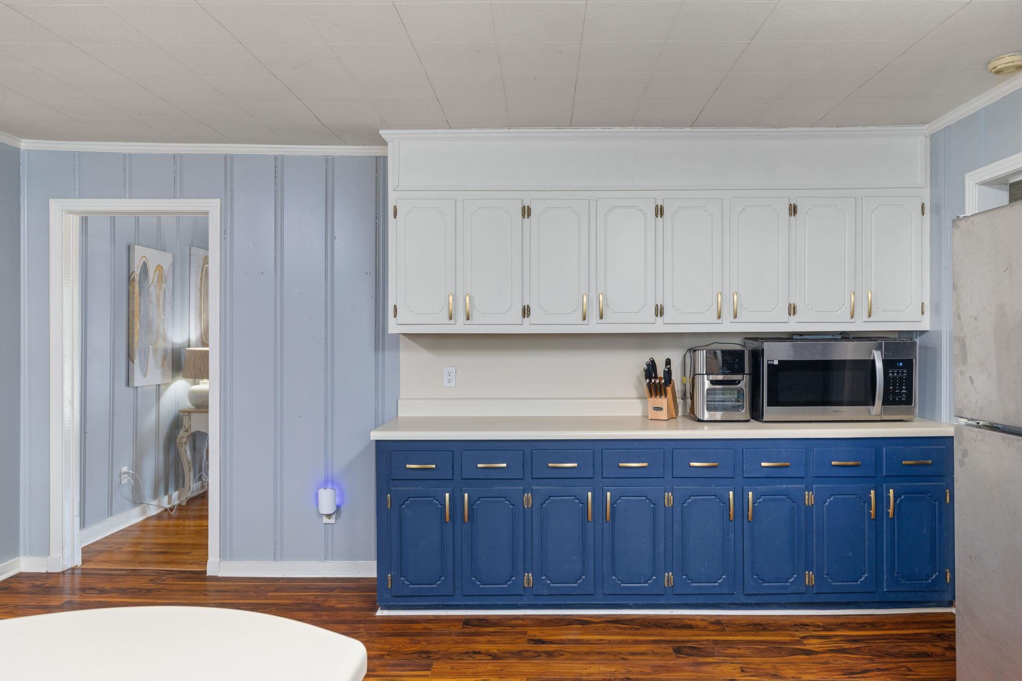 12 County Road 512 Corinth, MS 38834 - Photo 34 of 39 Dual tone kitchen featuring light countertops, ornamental molding, dark wood-style flooring, stainless steel appliances, and two tone cabinets