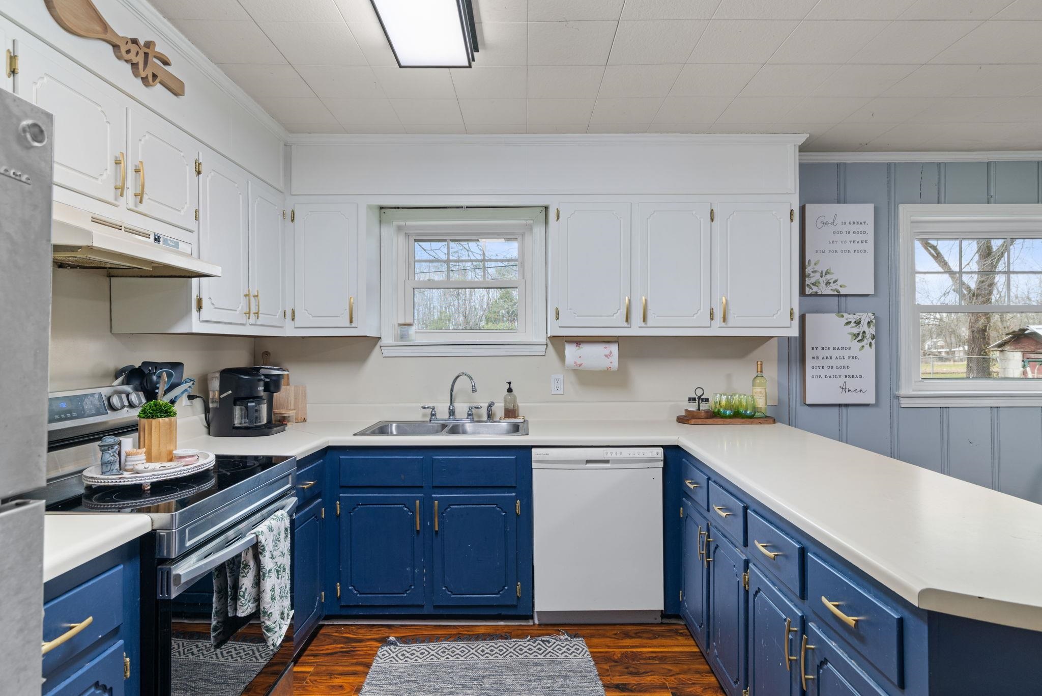 12 County Road 512 Corinth, MS 38834 - Photo 6 of 39 Two tone kitchen featuring stainless steel appliances, light countertops, crown molding, dual tone cabinetry, and dark wood-style floors
