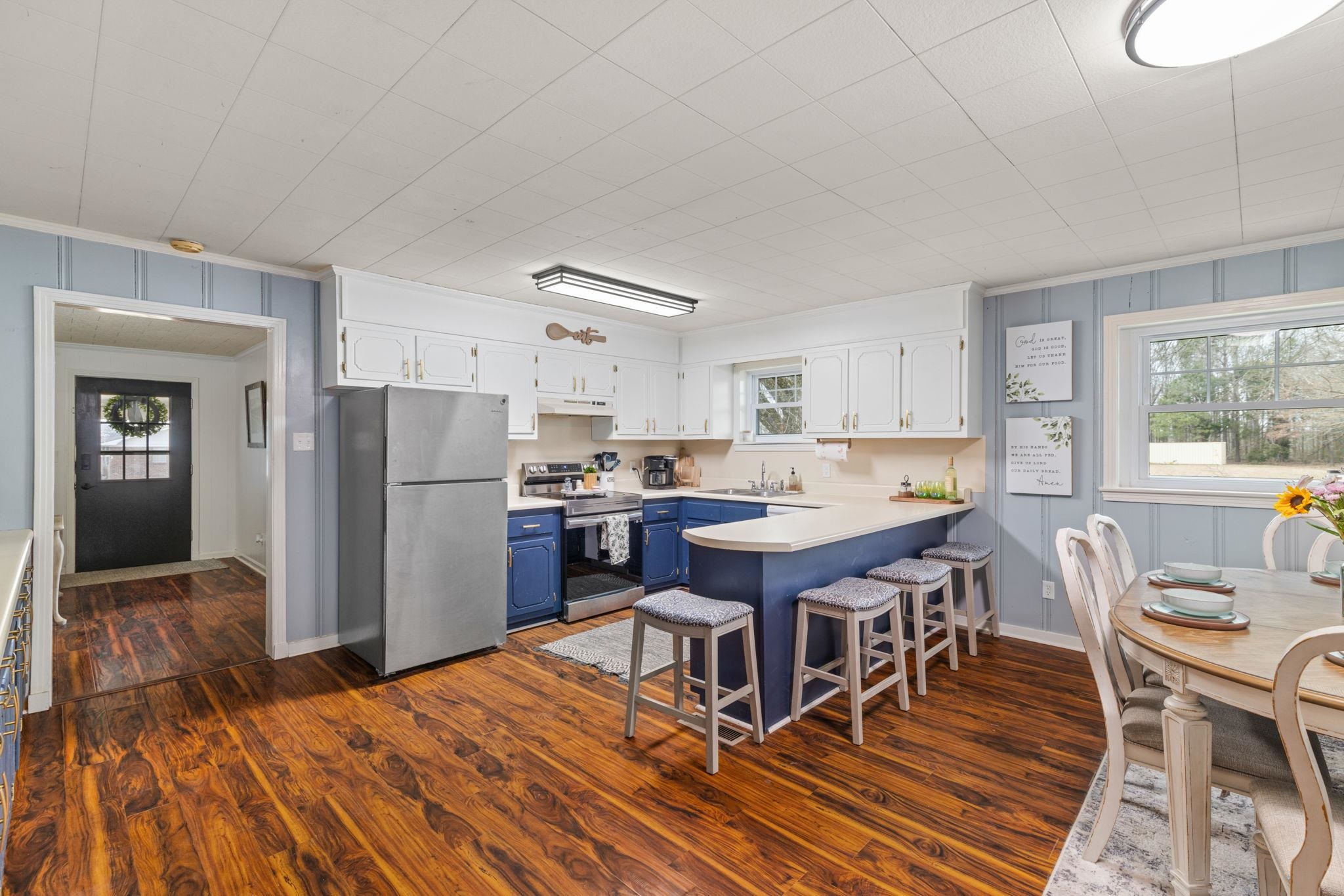 12 County Road 512 Corinth, MS 38834 - Photo 10 of 39 Two tone kitchen featuring two tone cabinets, stainless steel appliances, a peninsula, healthy amount of natural light, and light countertops