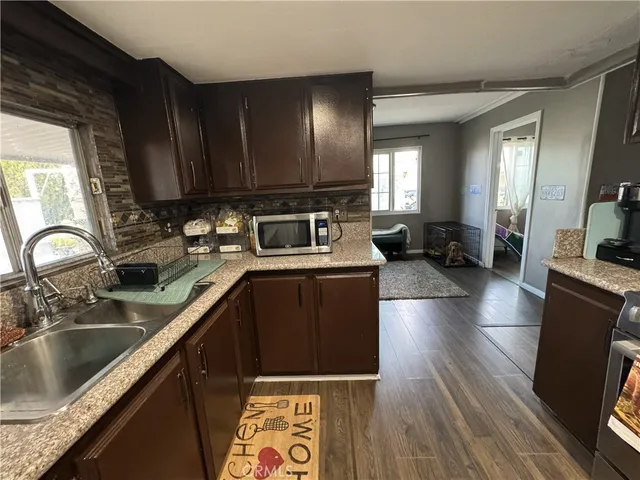 a kitchen with granite countertop a sink dishwasher stove and cabinets