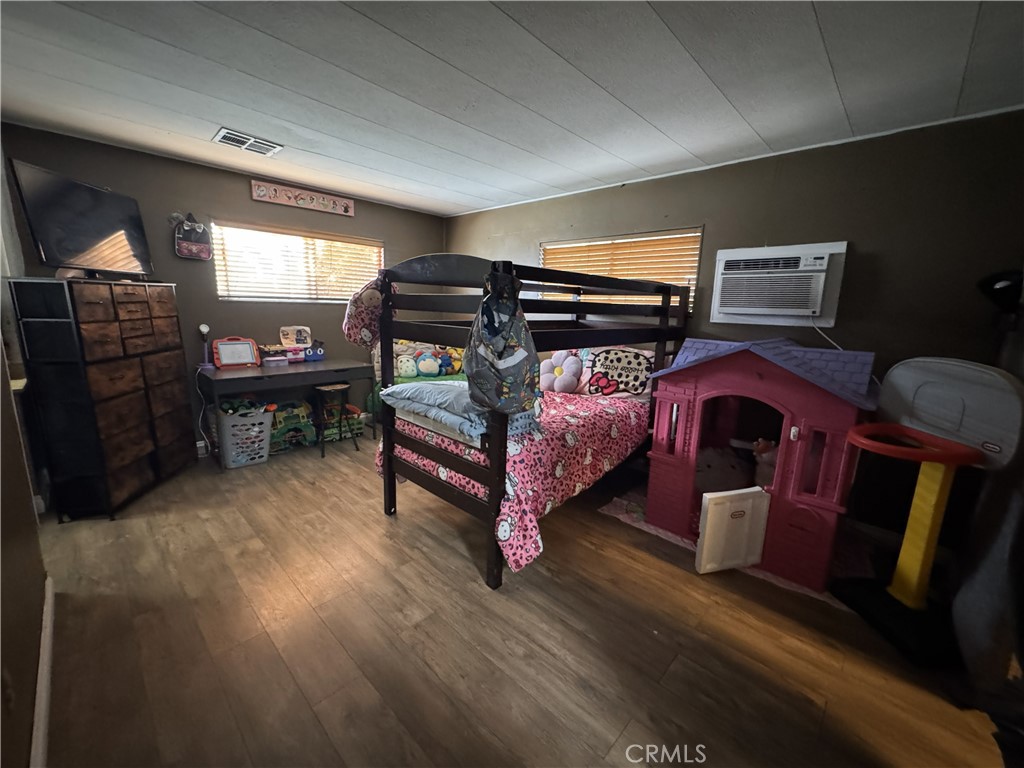 1025 South Riverside Avenue, Unit 66 Rialto, CA 92376 - Photo 27 of 53 a bedroom with furniture and wooden floor