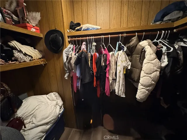 a view of walk in closet with clothes and shoes