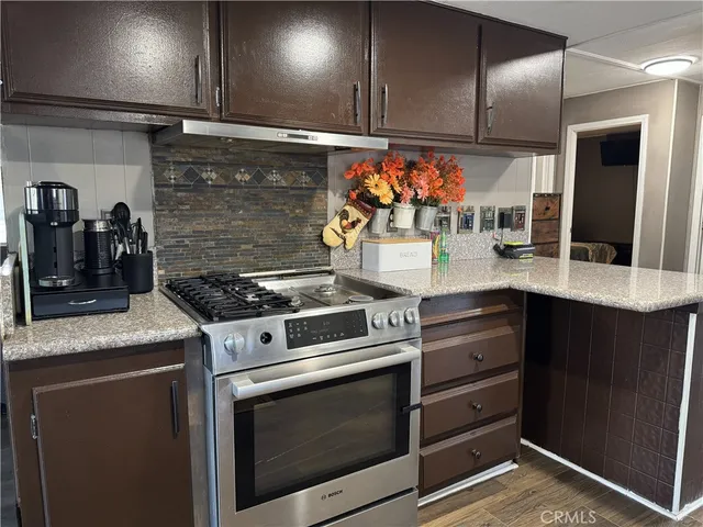 a kitchen with stainless steel appliances granite countertop a stove and a microwave
