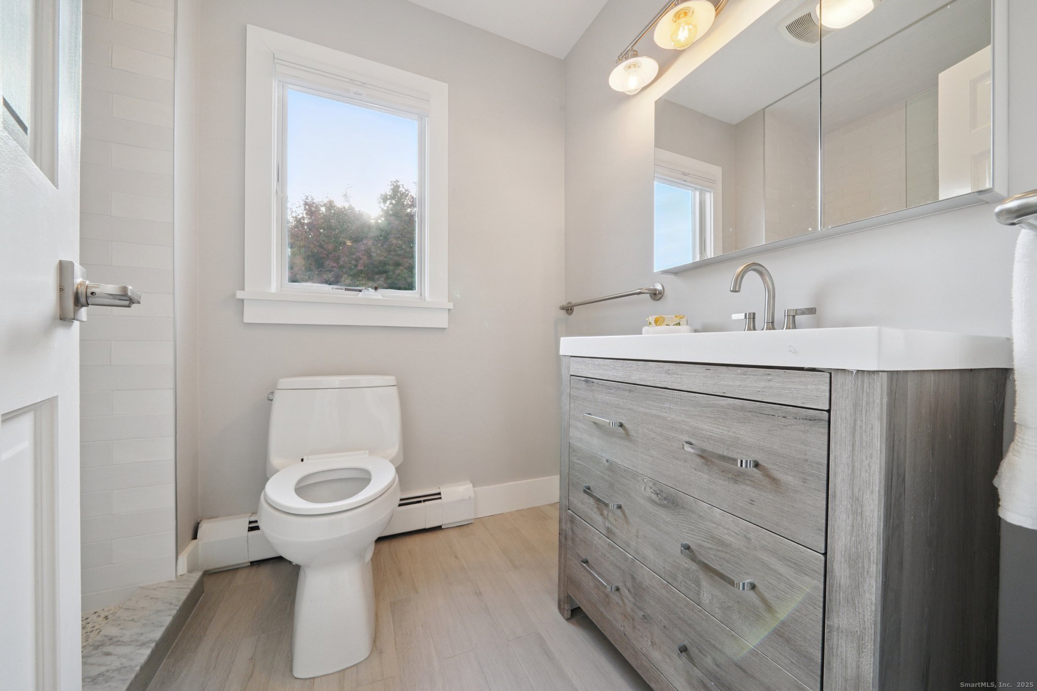 656 Fairfield Beach Road Fairfield, CT 06824 - Photo 17 of 30 a bathroom with a sink toilet and mirror
