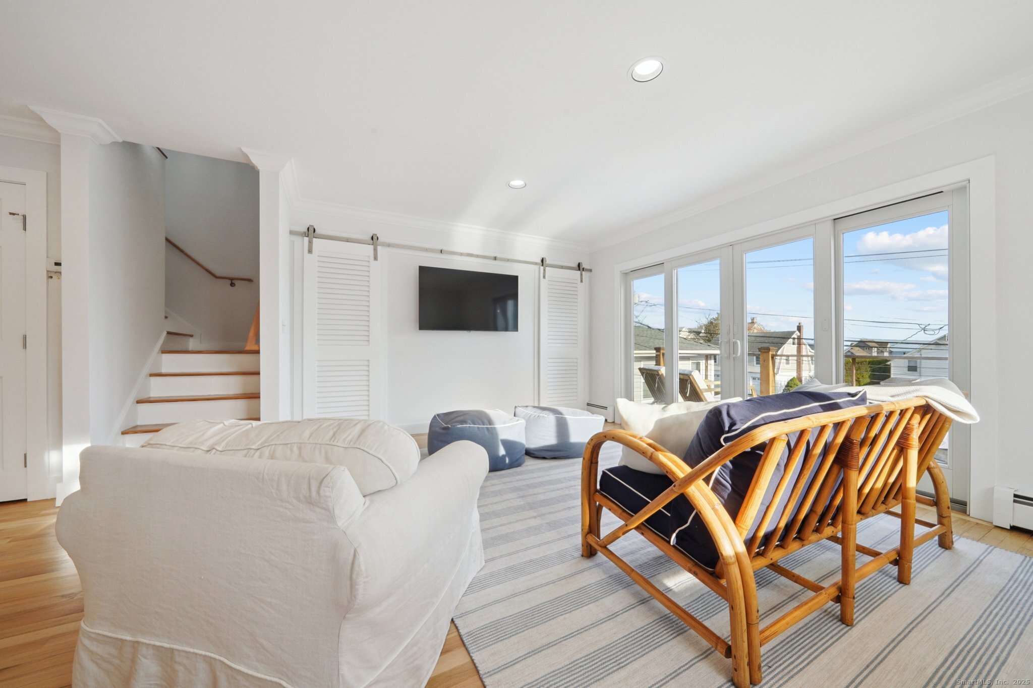 656 Fairfield Beach Road Fairfield, CT 06824 - Photo 19 of 30 a living room with furniture a flat screen tv and a large window