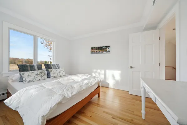 a bedroom with a bed and wooden floor