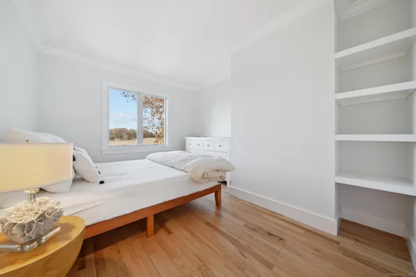 a bedroom with a bed and wooden floor