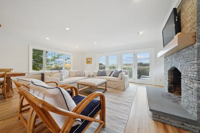 a living room with furniture kitchen area and a wooden floor
