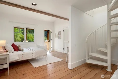 a bedroom with a bed and a large window