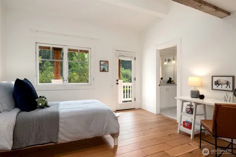 a bedroom with a bed window and table