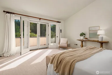 a bedroom with a bed and a large window