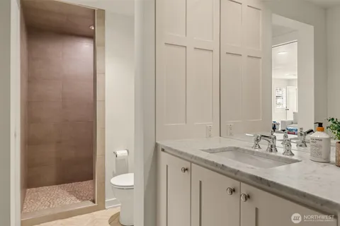 a bathroom with a granite countertop sink a toilet and shower