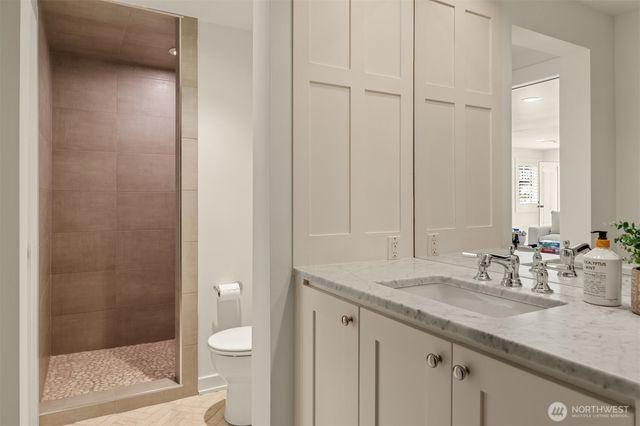 a bathroom with a granite countertop sink a toilet and shower