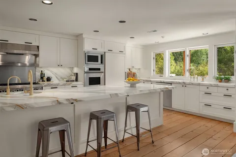 a kitchen with a sink stove window and cabinets
