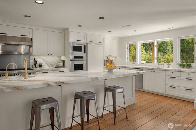 a kitchen with a sink stove window and cabinets