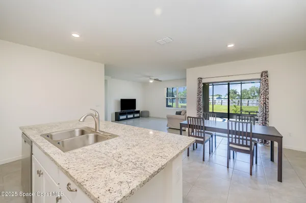 a kitchen with a table chairs and wooden floor