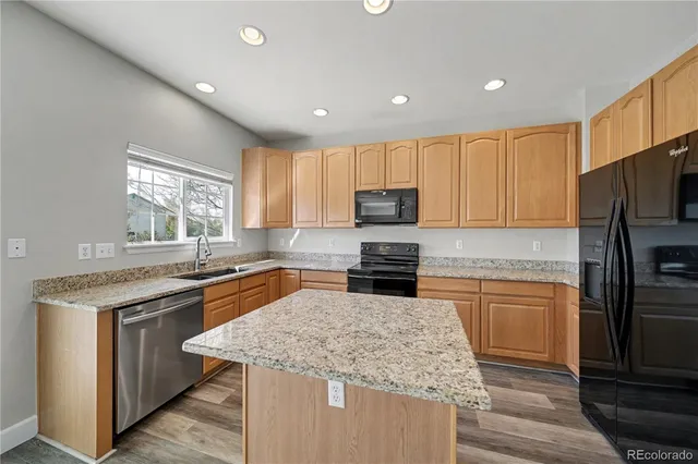 a kitchen with stainless steel appliances granite countertop refrigerator sink and microwave