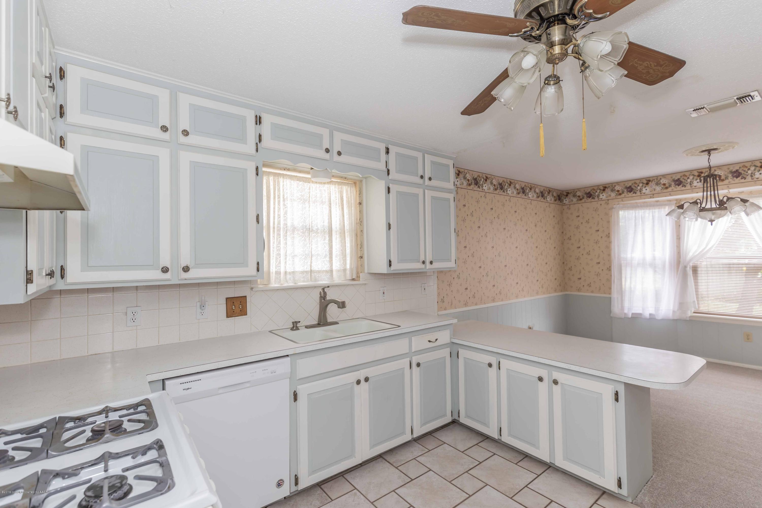 7206 Gainsborough Road Amarillo, TX 79106 - Photo 12 of 41 a kitchen with white cabinets and white appliances
