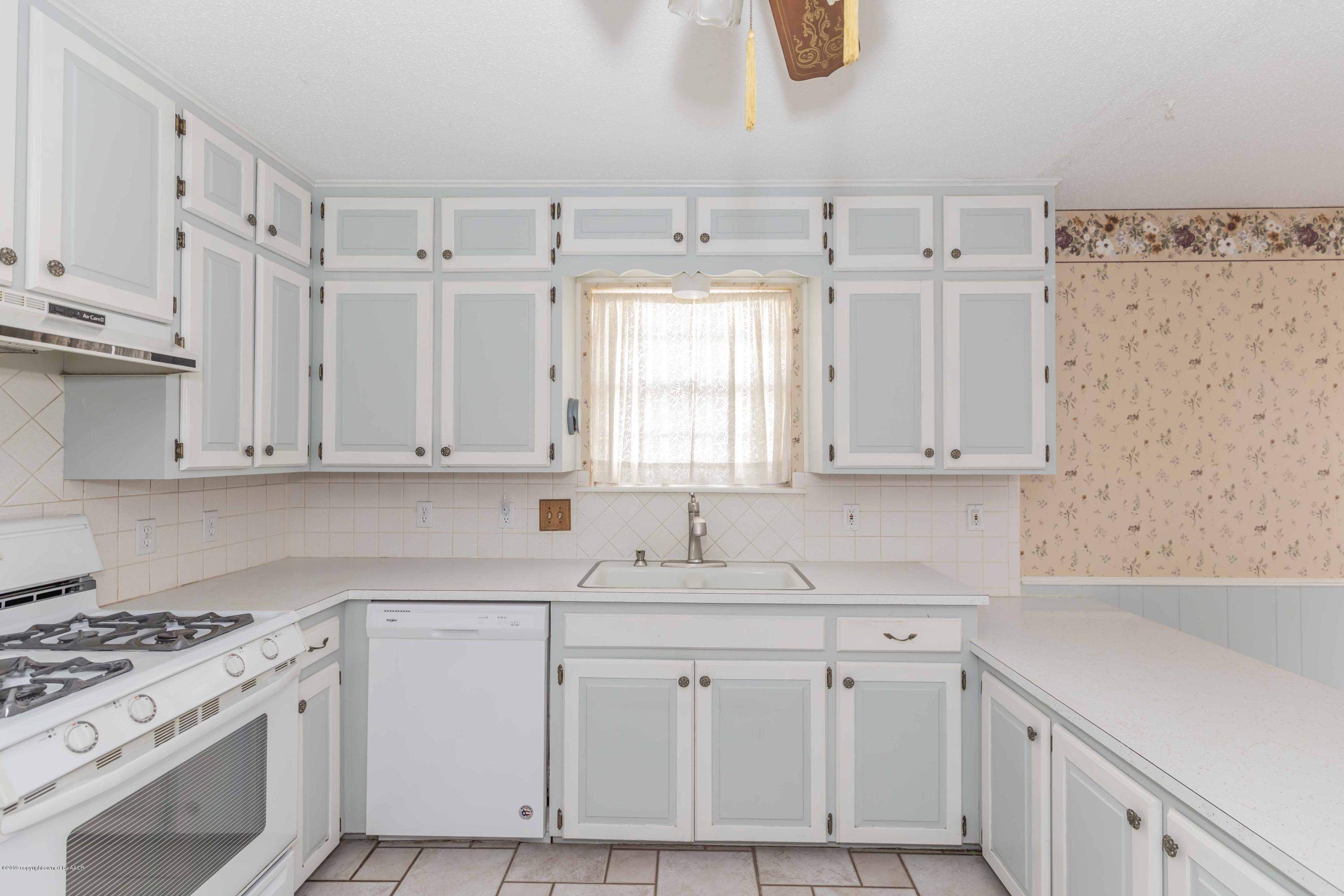 7206 Gainsborough Road Amarillo, TX 79106 - Photo 13 of 41 a kitchen with granite countertop a white sink and white cabinets