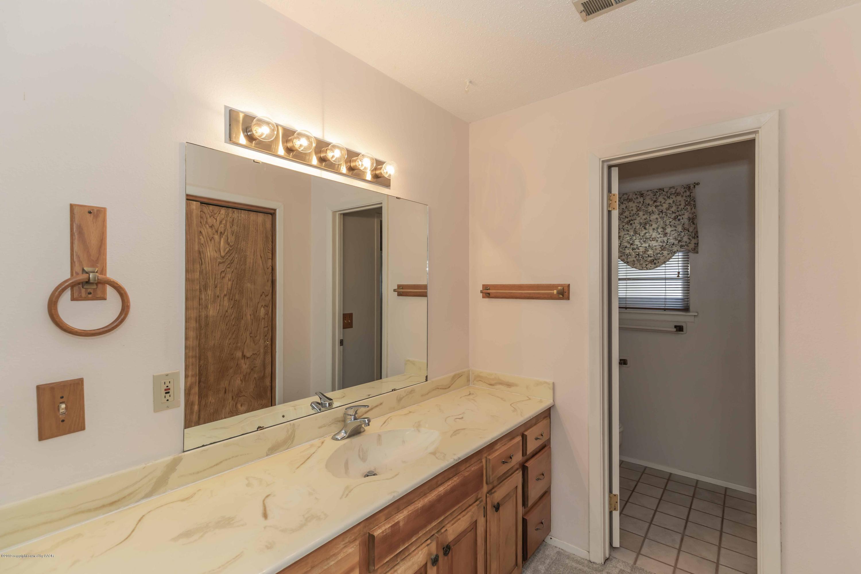 7206 Gainsborough Road Amarillo, TX 79106 - Photo 21 of 41 a bathroom with a granite countertop sink and a mirror