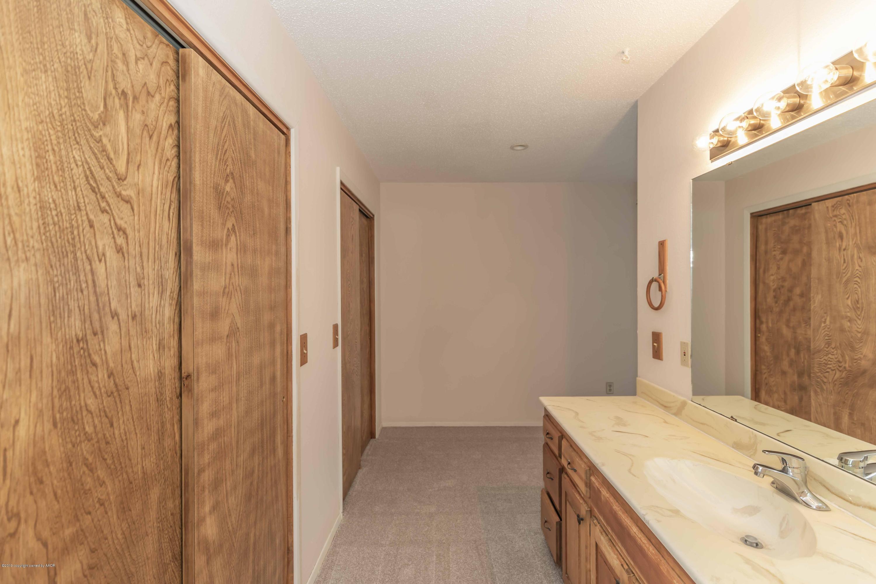7206 Gainsborough Road Amarillo, TX 79106 - Photo 22 of 41 a bathroom with a granite countertop sink and a mirror
