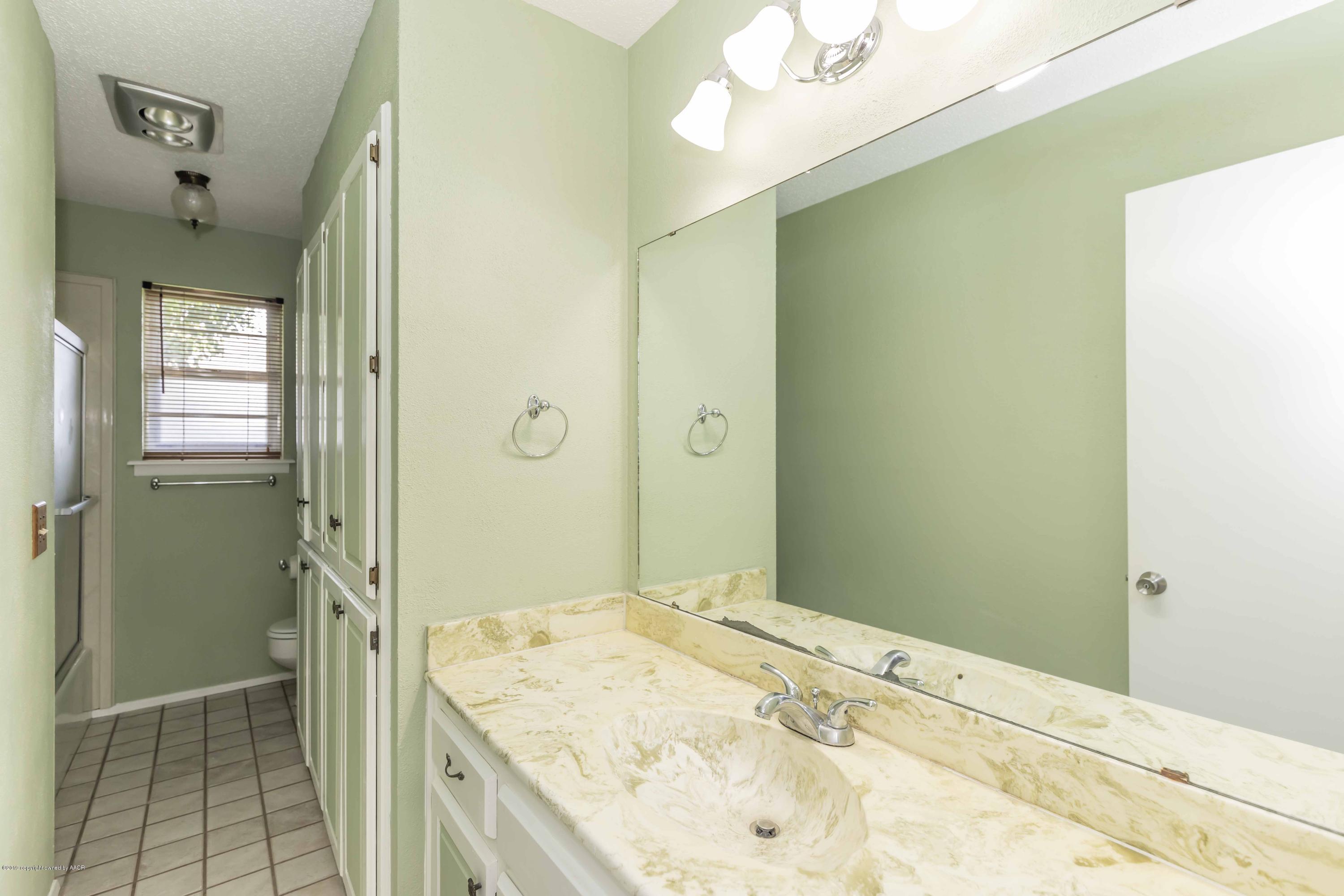 7206 Gainsborough Road Amarillo, TX 79106 - Photo 33 of 41 a bathroom with a granite countertop sink a mirror and a shower
