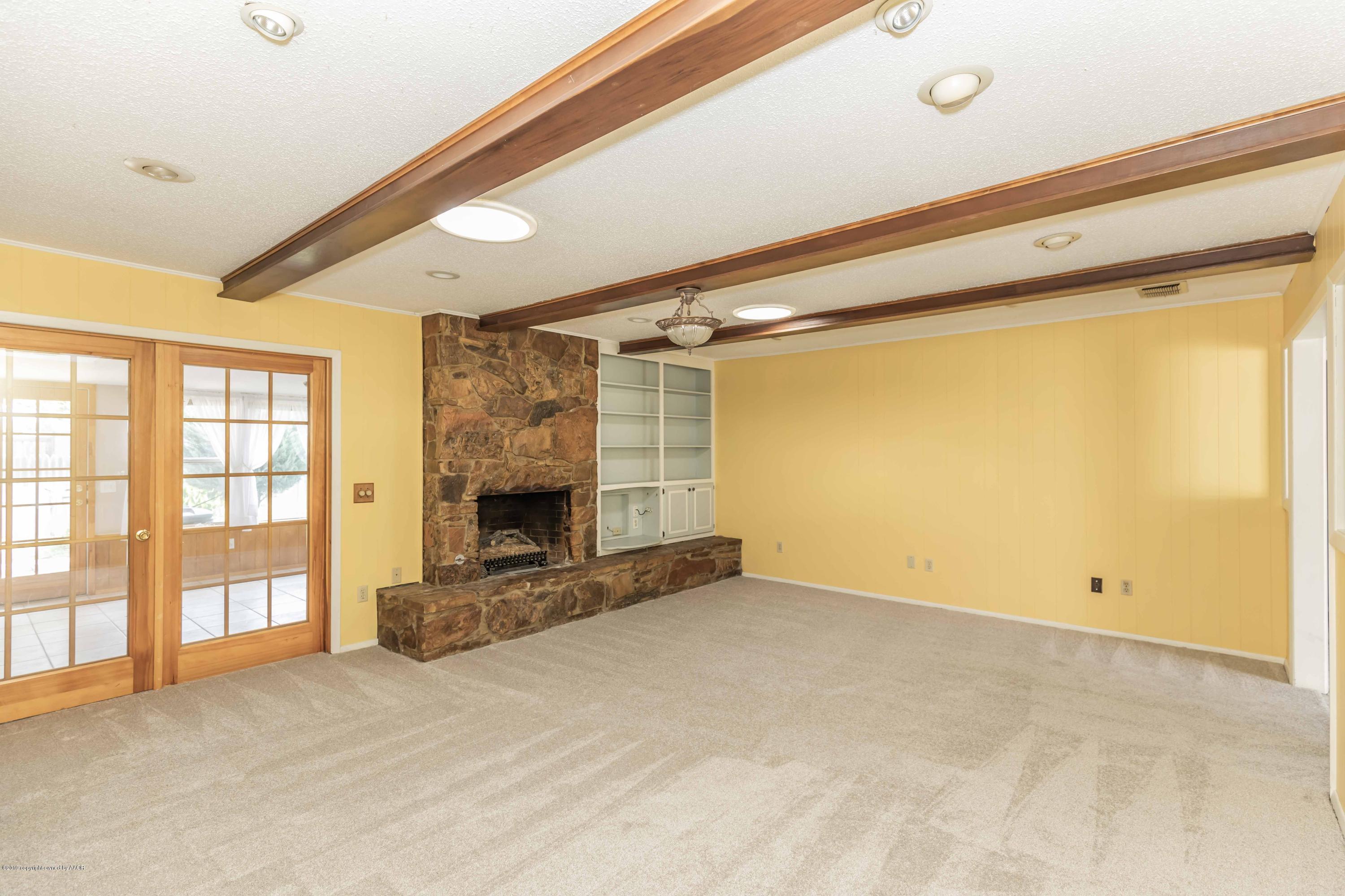 7206 Gainsborough Road Amarillo, TX 79106 - Photo 5 of 41 a view of an empty room with a fireplace and a window