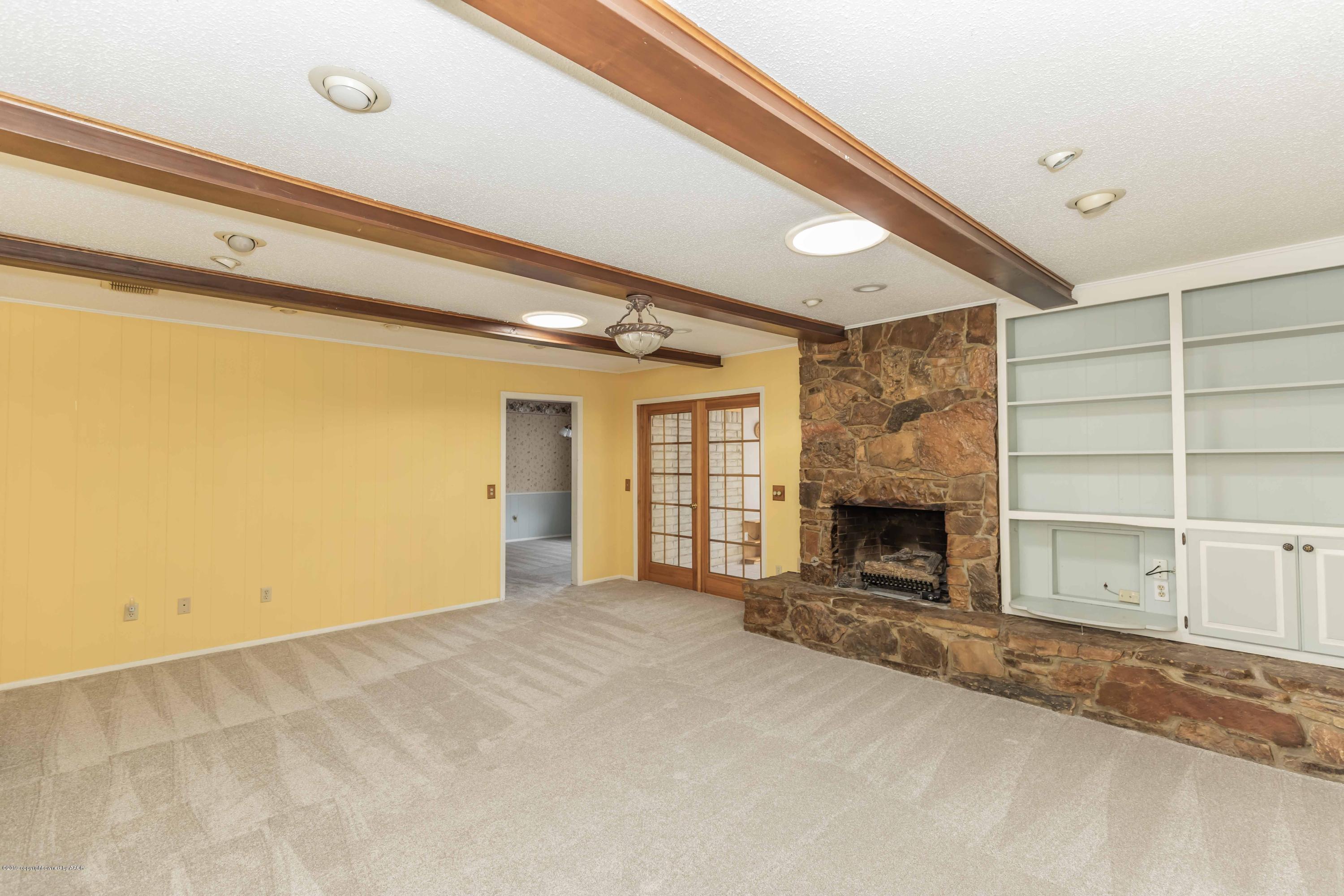 7206 Gainsborough Road Amarillo, TX 79106 - Photo 7 of 41 a view of an empty room with a fireplace and a window