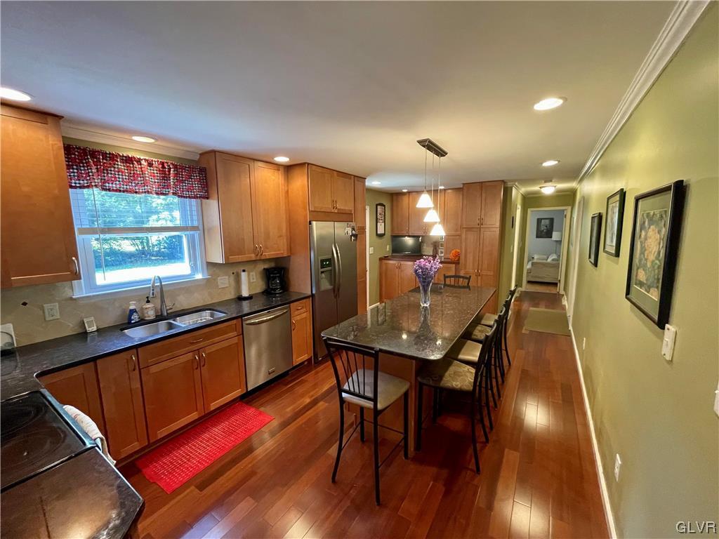 1295 Stark Road Bethlehem, PA 18017 - Photo 11 of 36 a kitchen with stainless steel appliances granite countertop a refrigerator a sink dishwasher a stove a dining table and chairs with wooden floor