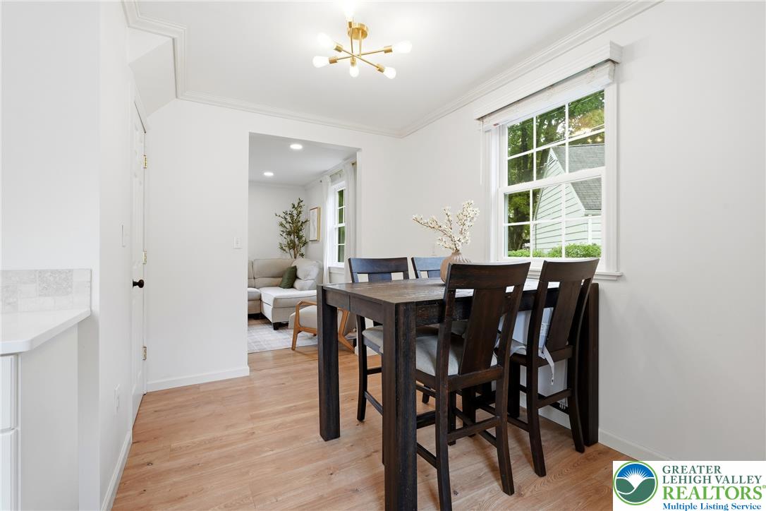 408 Maple Road Hellertown, PA 18055 - Photo 11 of 66 Hardwood floors and classic crown molding elevate this welcoming dining area with backyard views.