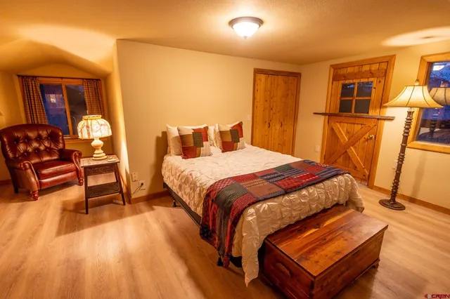 a bed sitting in a bedroom next to a lamp