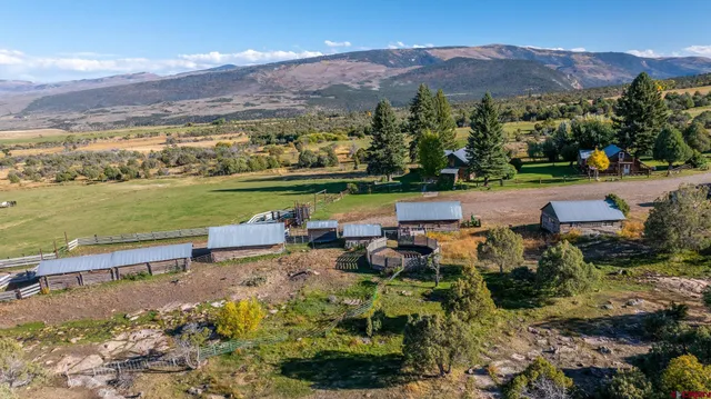 an aerial view of a house with garden space and mountain view in back