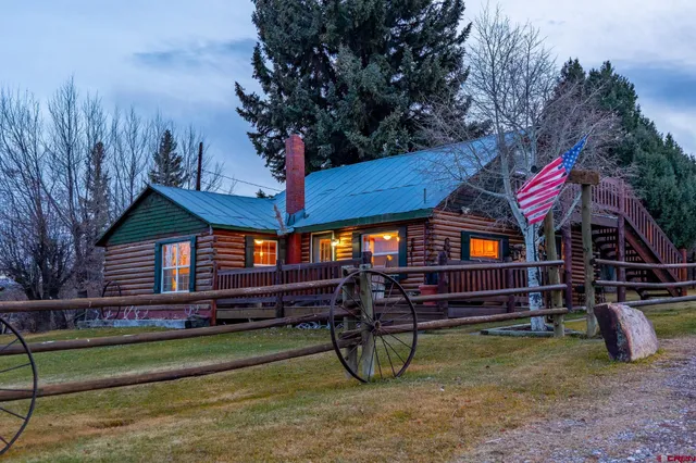 a view of a house with a yard and wooden fence