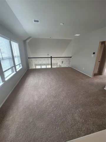a view of an empty room with chandelier and closet