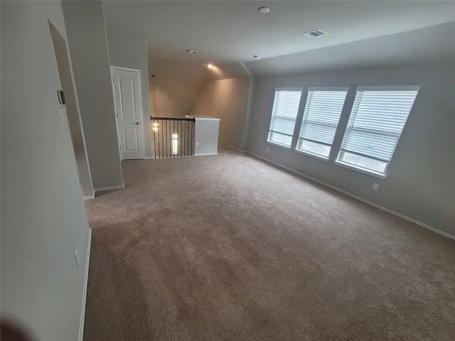 a view of an empty room and a kitchen