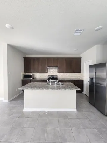 a view of kitchen with refrigerator sink and stove