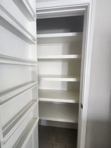 a view of walk in closet with empty racks