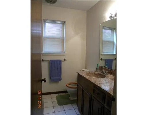 a bathroom with a granite countertop sink a toilet and a mirror
