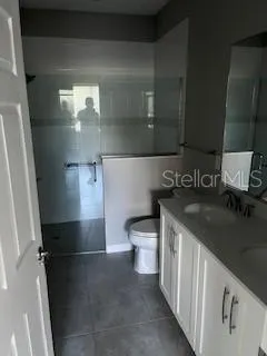 a bathroom with a granite countertop sink a toilet and a vanity